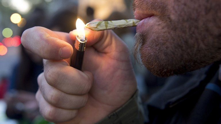 A man lights a marijuana cigarette during a demonstration in Montevideo on 8 May, 2013