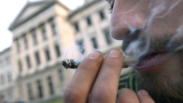 A man smokes marijuana outside the Congress where lawmakers debate a bill to legalize marijuana and regulate production and distribution in Montevideo, Uruguay, Wednesday, July 31, 2013.