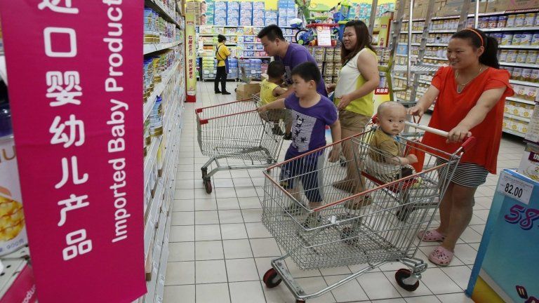 A family looks at imported milk powder products at a supermarket in Beijing in this July 3, 2013 file photo.