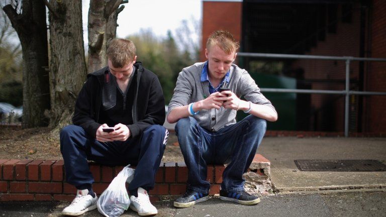 Two young men looking at their mobile phones