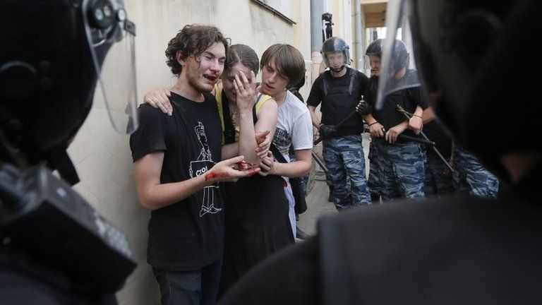 Russian police guard gay rights activists after they were attacked by rival protesters in St Petersburg, 29 June 2013