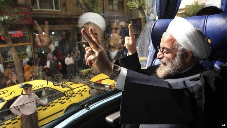 In this Monday, 10 June, 2013 photo, Iranian President elect, Hasan Rouhani, a former Iran"s top nuclear negotiator, waves, from his bus, during his presidential election campaign tour to the western city of Sanandaj, Iran.