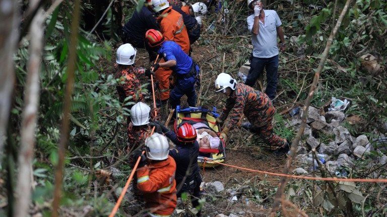 Malaysian emergency services personnel rescue a passenger (C) after a bus carrying tourists and local residents fell into a ravine near the Genting Highlands, about an hour"s drive from Kuala Lumpur on August 21, 2013