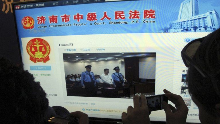 A journalist takes photos of a microblog by Jinan Intermediate People's Court on 22 August 2013