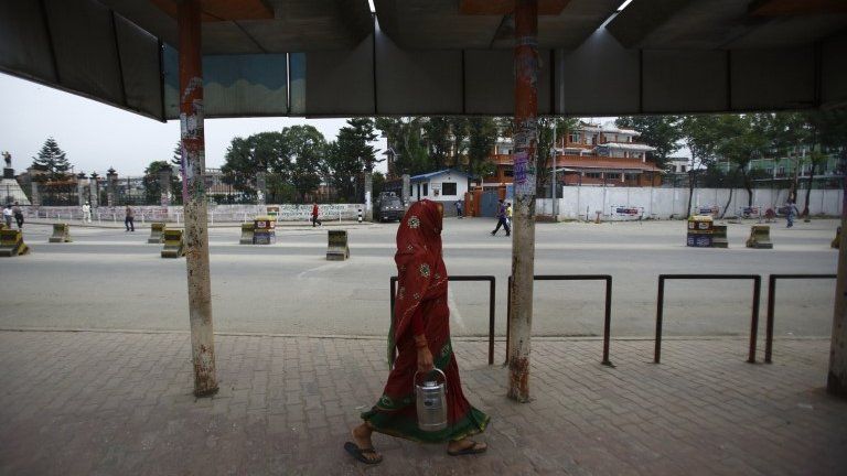 A woman walks past an empty bus stand during a general strike in Kathmandu September 12, 2013