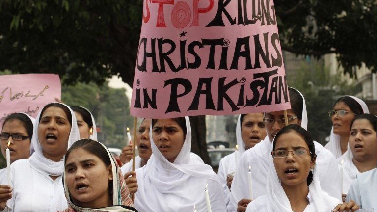 Members of the Pakistani Christian community hold a placard as they shout slogans during a protest rally to condemn Sunday"s suicide attack in Peshawar on a church