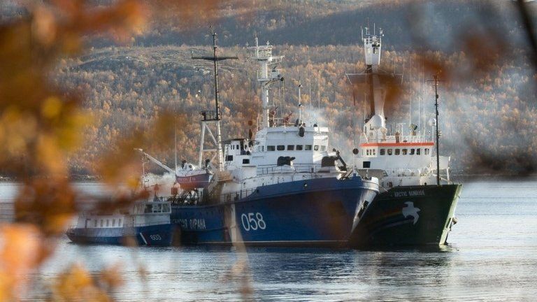 In an image made available by Greenpeace the Greenpeace ship, the Arctic Sunrise, right, is anchored side by side with the Russian Coast Guard Ship in the Kolskii gulf, near Murmansk, Russia on Monday, 30 September, 2013.