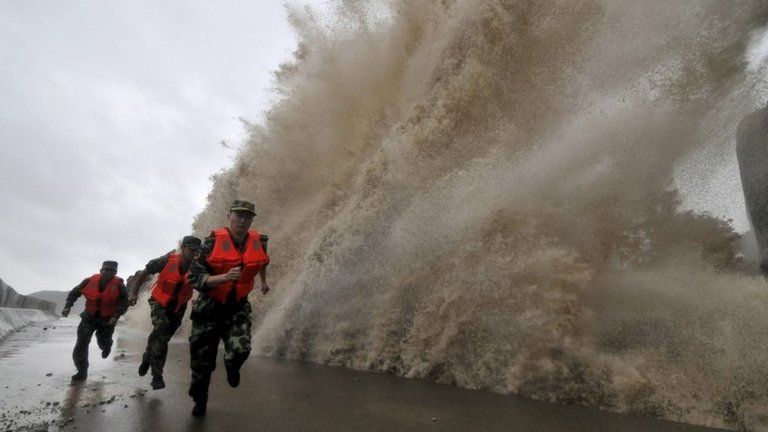 Chinese soldiers run as a storm surge hits Wenling, Zhejiang province. Photo: 6 October 2013