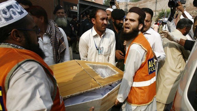 Relatives and rescue workers carry the coffin of a man killed in a bomb blast on 7 October 2013 at hospital in Peshawar