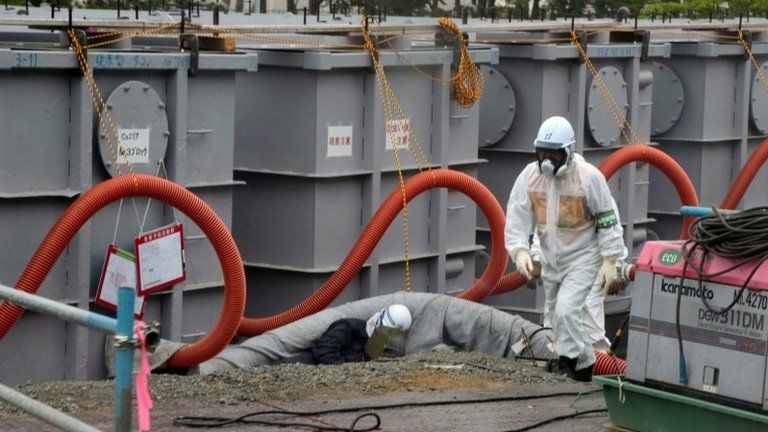 Tokyo Electric Power Co (Tepco) workers work on waste water tanks at Japan's Fukushima Dai-ichi nuclear plant in the town of Okuma, Fukushima prefecture in Japan on 12 June 2013