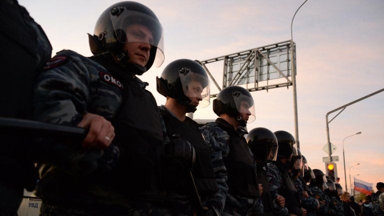 Russian riot police block a street during an unauthorised rally in Moscow's Biryulevo Zapadnoye district on 13 October 2013