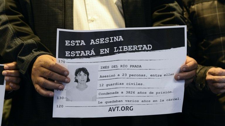 An activist holds a placard which reads "This murderer will be free", alongside a picture of Ines Del Rio.