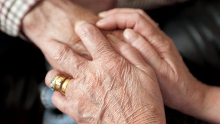 Carer holding hands with patient