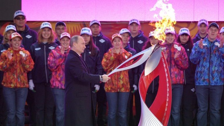 Russian President Vladimir Putin lights a Sochi Olympic torch in Moscow, 6 October