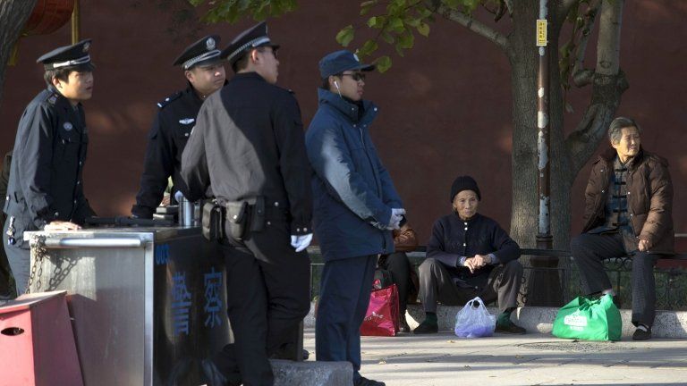 Elderly Chinese women sit on the sidewalk near a security checkpoint set up as part of the increased security during a weekend gathering of the Communist Party's 205-member Central Committee for its third annual plenum in Beijing Tuesday, Nov 12, 2013.