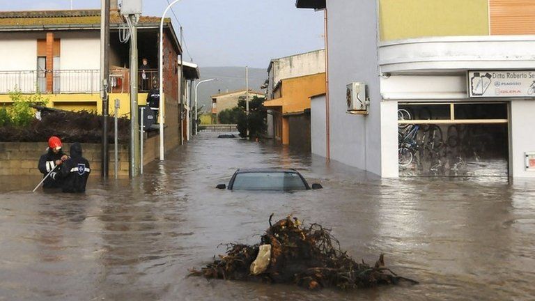 Rescuers work on a flooded street in the town of Uras, Sardinia. Photo: 18 November 2013