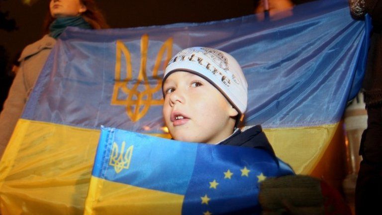 A child holds a Ukrainian and EU flags in Kiev. Photo: 22 November 2013