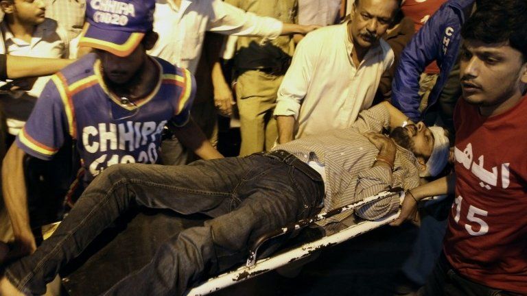 Pakistani rescue workers carry an injured victim of bomb explosion to a hospital in Karachi.