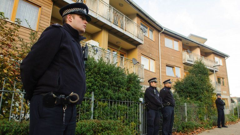 Police standing guard outside flats in south London