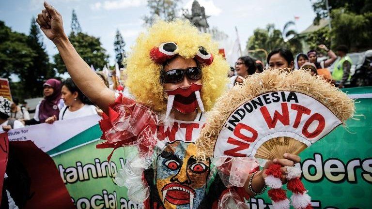 Indonesian activists wears anti WTO costumes during a protest against the World Trade Organization