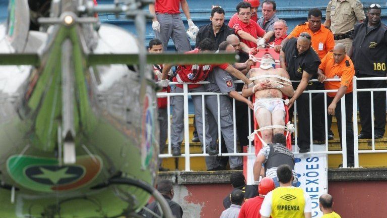 Injured Brazilian football fan being transported out of stadium