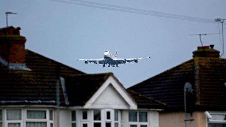 A plane flying over houses into Heathrow