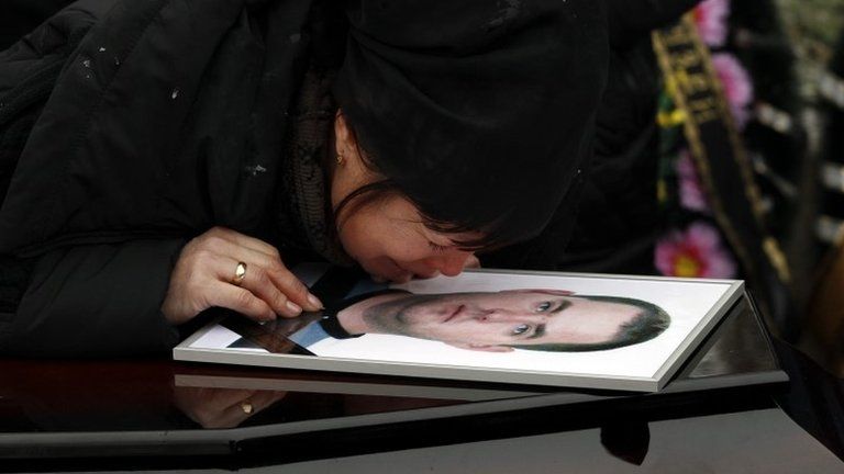A relative grieves over the coffin of a victim of the Volgograd attacks, 31 December