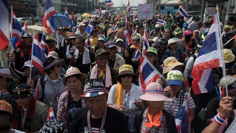 Thai anti-government protesters wave national flags during a rally in Bangkok on 7 January 2014