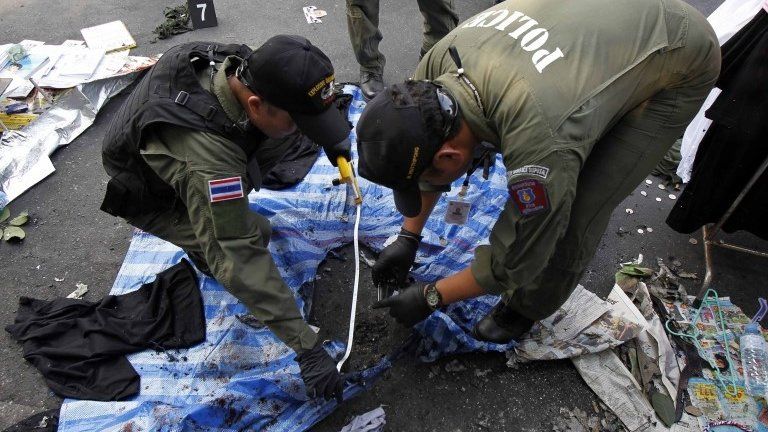 Thai policemen check the scene following an explosion near a camp of anti-government protesters at the Victory monument in central Bangkok January 19