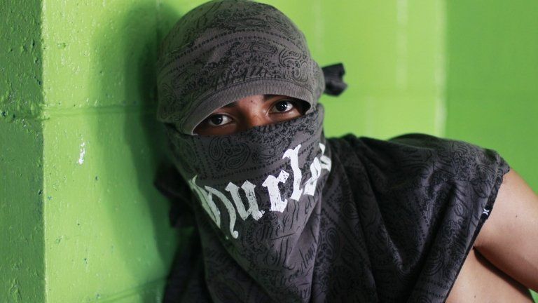 A member of the Barrio 18 gang poses for a photograph at a bakery in a neighbourhood in Ilopango, El Salvador