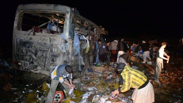 Pakistani Shiite Muslims search the wreckage of a destroyed pilgrims bus after a bomb attack in Baluchistan province on 21 January.