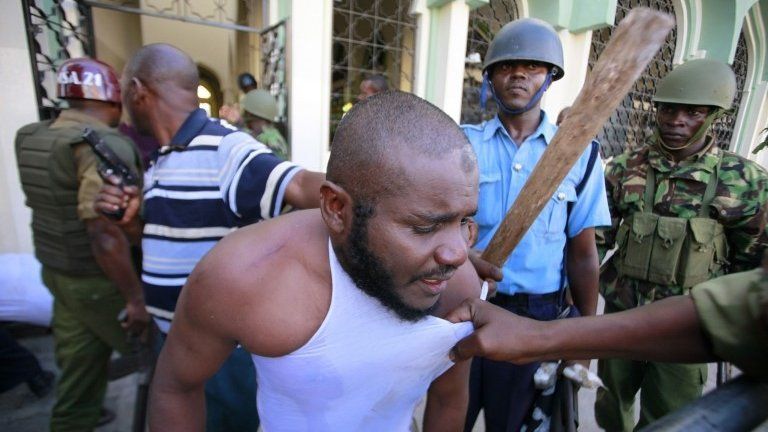 A Muslim man is detained by police officers at the Masjid Mussa Mosque in Kenya"s coastal town of Mombasa February 2, 2014.