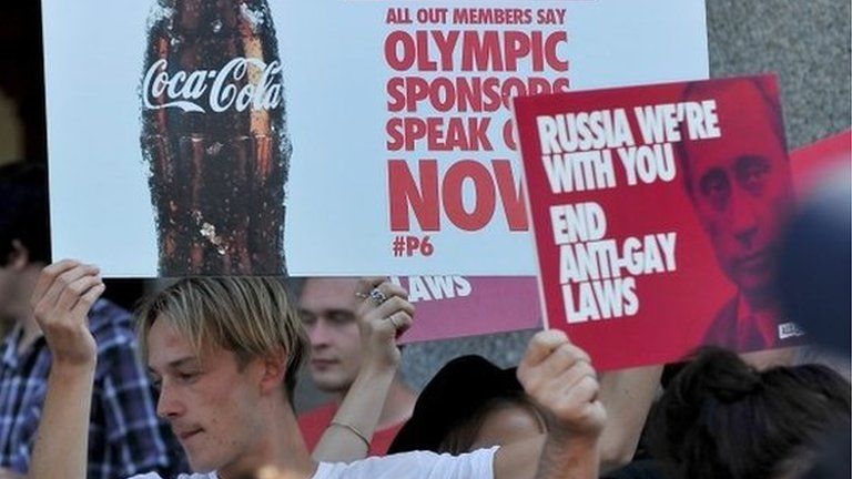Pro-gay activists hold placards calling for Sochi Winter Olympic sponsors to speak out against Russia's anti-gay laws during a protest in Melbourne on Wednesday