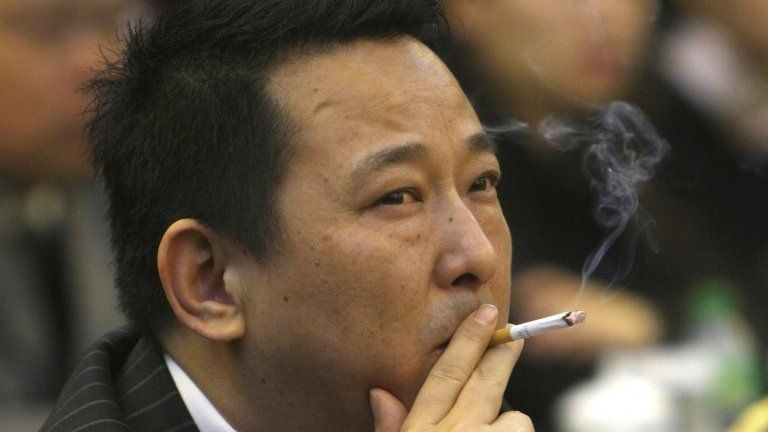 File photo: Liu Han, former chairman of Hanlong Mining, smokes a cigarette during a conference in Mianyang, Sichuan province, 21 March 2008