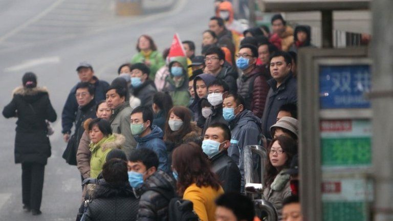 This picture taken on 24 February 2014 shows residents waiting for buses in a bus station in haze-covered Beijing