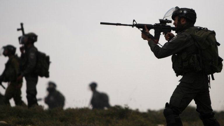 Israeli border police officer fires rubber bullets during a protest near the West Bank village of Deir Jarir (May 2013)
