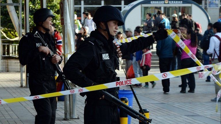 Chinese police stand guard at the scene of an attack at the main train station in Kunming, Yunnan province, China, 2 March 2014