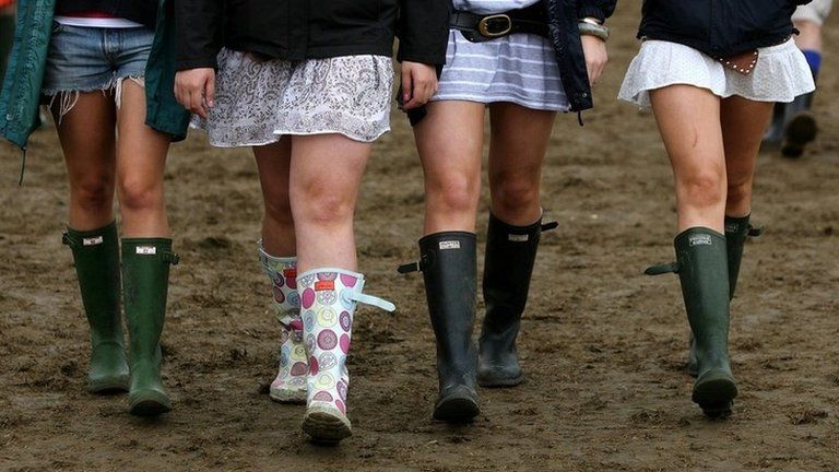 Girls walking in mud at festival