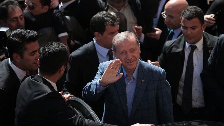 Turkey"s Prime Minister Recep Tayyip Erdogan, center, salutes his supporters outside a polling station in Istanbul, Turkey, Sunday, March 30, 2014.