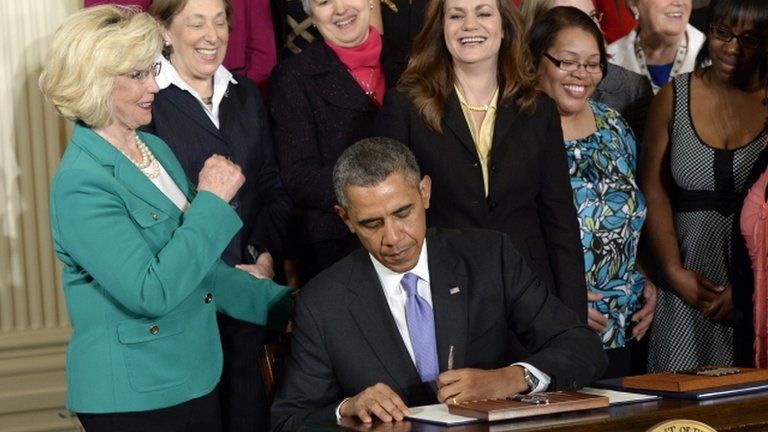 President Barack Obama (centre) signs executive actions in Washington DC on 8 April 2014