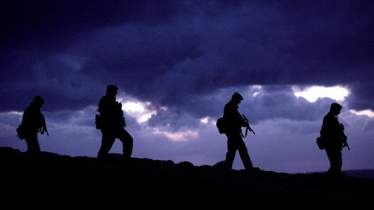 Four soldiers seen in silhouette