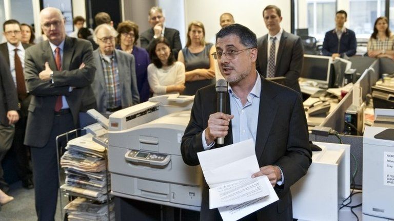 After the Pulitzer Prize for Public Service was awarded to The Washington Post, reporters and editors gather in the newsroom in Washington 14 April 2014