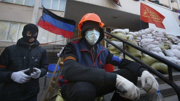 Masked pro-Russian protesters guard a barricade in front of the city hall in Mariupol, eastern Ukraine, Thursday, April 17, 2014
