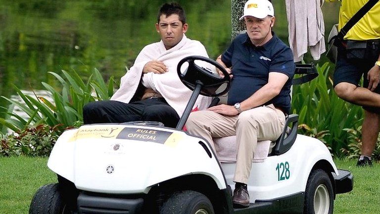 Pablo Larrazabal (left) is driven away from the lake by a Tour official