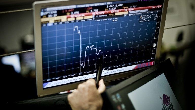 A trader point at a graphic on a computer screen in Lisbon