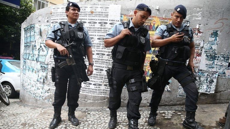 Police keep watch near the pacified Pavao-Pavaozinho community, just blocks from Copacabana Beach, on April 23, 2014