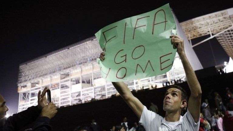 A member of Brazil's Homeless Workers" Movement holds up a banner in front of Sao Paulo's World Cup stadium on 4 June, 2014