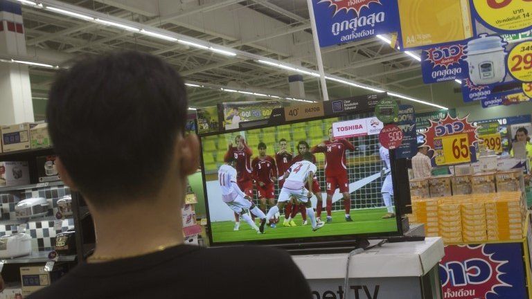 A Thai shopper watches a soccer match on a flat-panel television at s shopping mall in Bangkok, Thailand Wednesday, June 11
