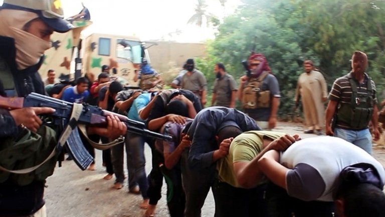 Picture apparently showing captured Iraqi soldiers in civilian clothes being led away by ISIS militants