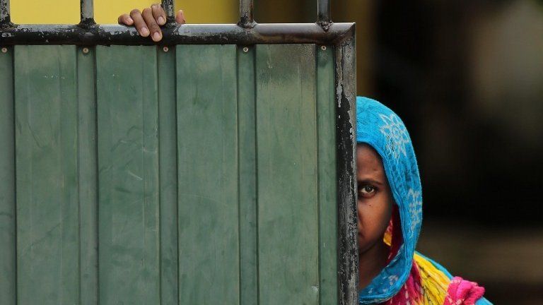 A Sri Lankan Muslim woman looks out on the street, in Aluthgama, town, 50 kilometers (31.25 miles) south of Colombo, Sri Lanka, Monday, June 16, 2014.